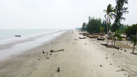 drone shot capturing the fishing boats and the wide shoreline of kuakata beach in bangladesh