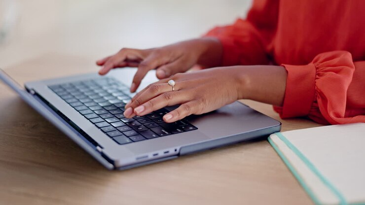 Die Frau, die auf dem Laptop schreibt
