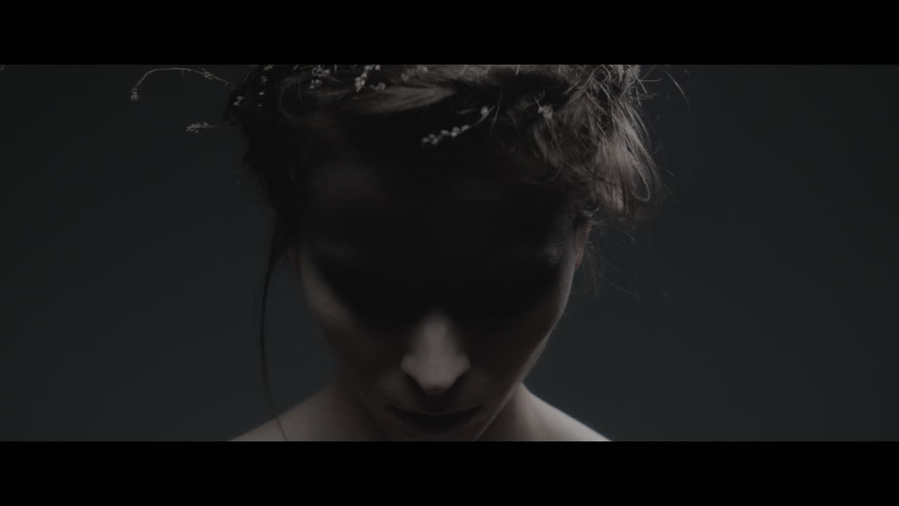 A woman dressed as mother nature lowers her head