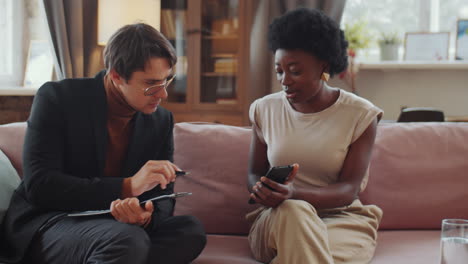 Woman-Discussing-Something-on-Smartphone-with-Psychologist