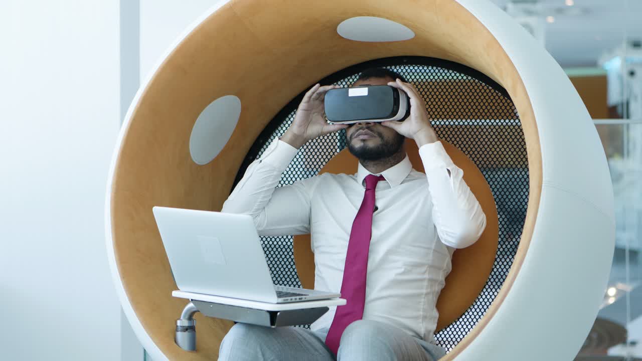 Businessman using laptop and vr headset