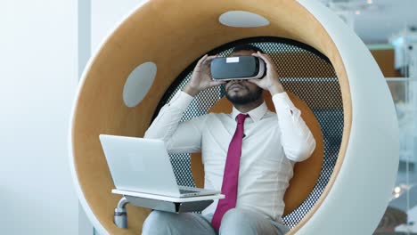 businessman using laptop and vr headset