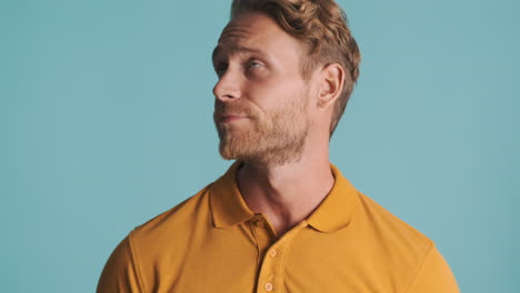 un hombre rubio cansado con una camiseta de polo.
