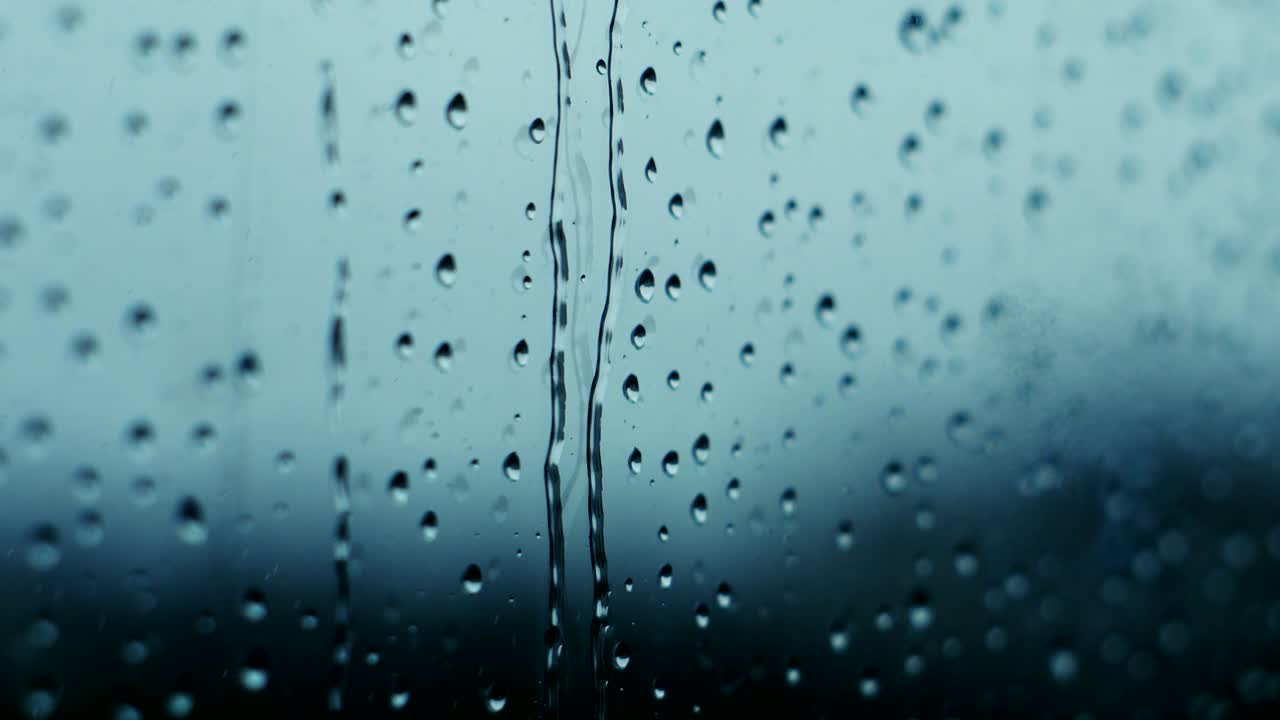gotas de lluvia corriendo por un vidrio de la ventana