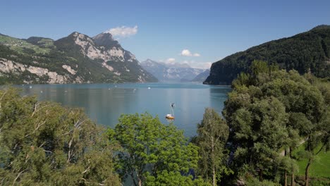 Beautiful-scenic-mountain-landscape-in-Europe-a-lake-yacht-club-and-boat-in-water-sport-leisure-high-peak-in-hazy-landscape-and-sunny-day-semi-cloudy-blue-sky-nature-concept-provide-outdoor-travelling