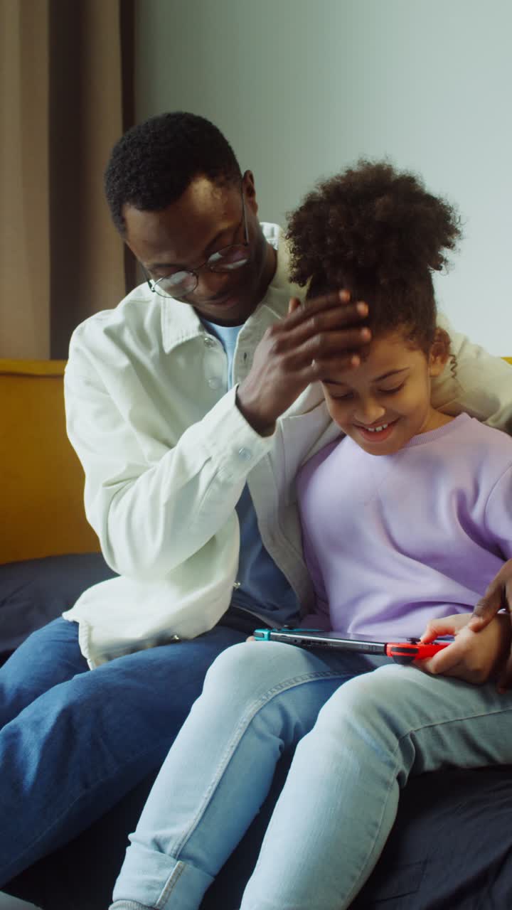 Padre e figlia giocano insieme ai videogiochi