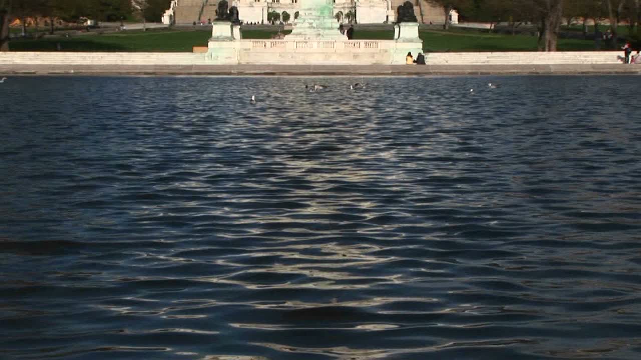 panoramización desde la piscina reflectante en washington dc y centrándose en el edificio del capitolio de estados unidos