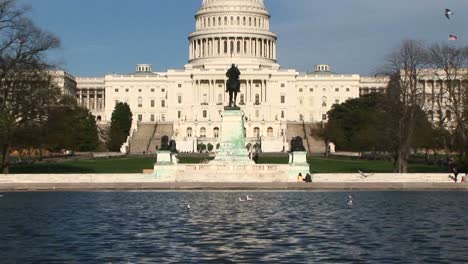 panoramización desde la piscina reflectante en washington dc y centrándose en el edificio del capitolio de estados unidos