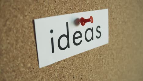 sticky note: ideas - pinned to cork wall - and removed