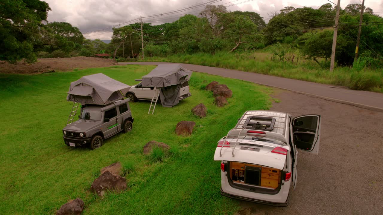 캠퍼 4x4의 영화적 드론 클립은 자연에서 푸른 목초지 밖에서 캠핑하는 경향이 있습니다.