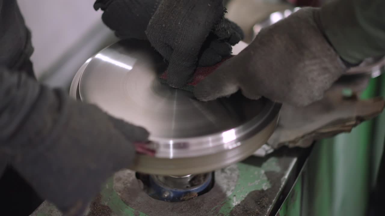 Using a belt sander to produce steel pan cookware in a factory