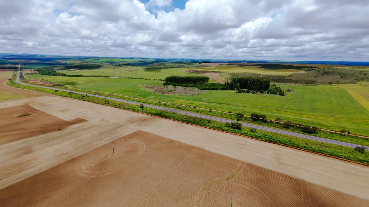Vast soybean plantation in Cerrado tropical savanna, Brazil, highlighting agricultural impacts on the landscape with visible deforestation and land conversion for crops, drone reveal shot
