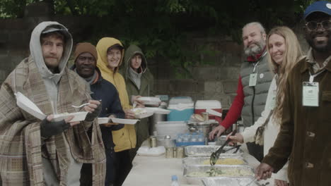 volunteers serving meals at an outdoor community food distribution event