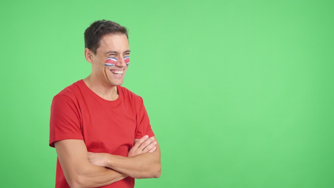 Hombre feliz con la bandera costarricense pintada en la cara, mirando hacia otro lado