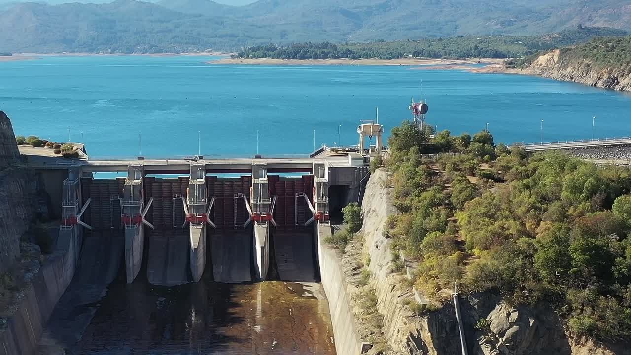 Vista del lago Colbún con presa en Chile y paisaje circundante.