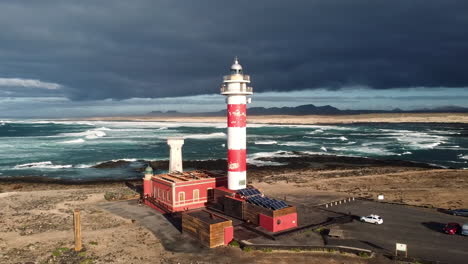 Vista-Aérea-Del-Faro-El-Toston-Y-El-Museo-Faro-El-Cotillo-Con-Las-Olas-Del-Océano-Atlántico-En-El-Fondo