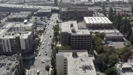 Busy-Californian-concrete-cityscape,-buildings-and-cars,-aerial-slide-truck-view