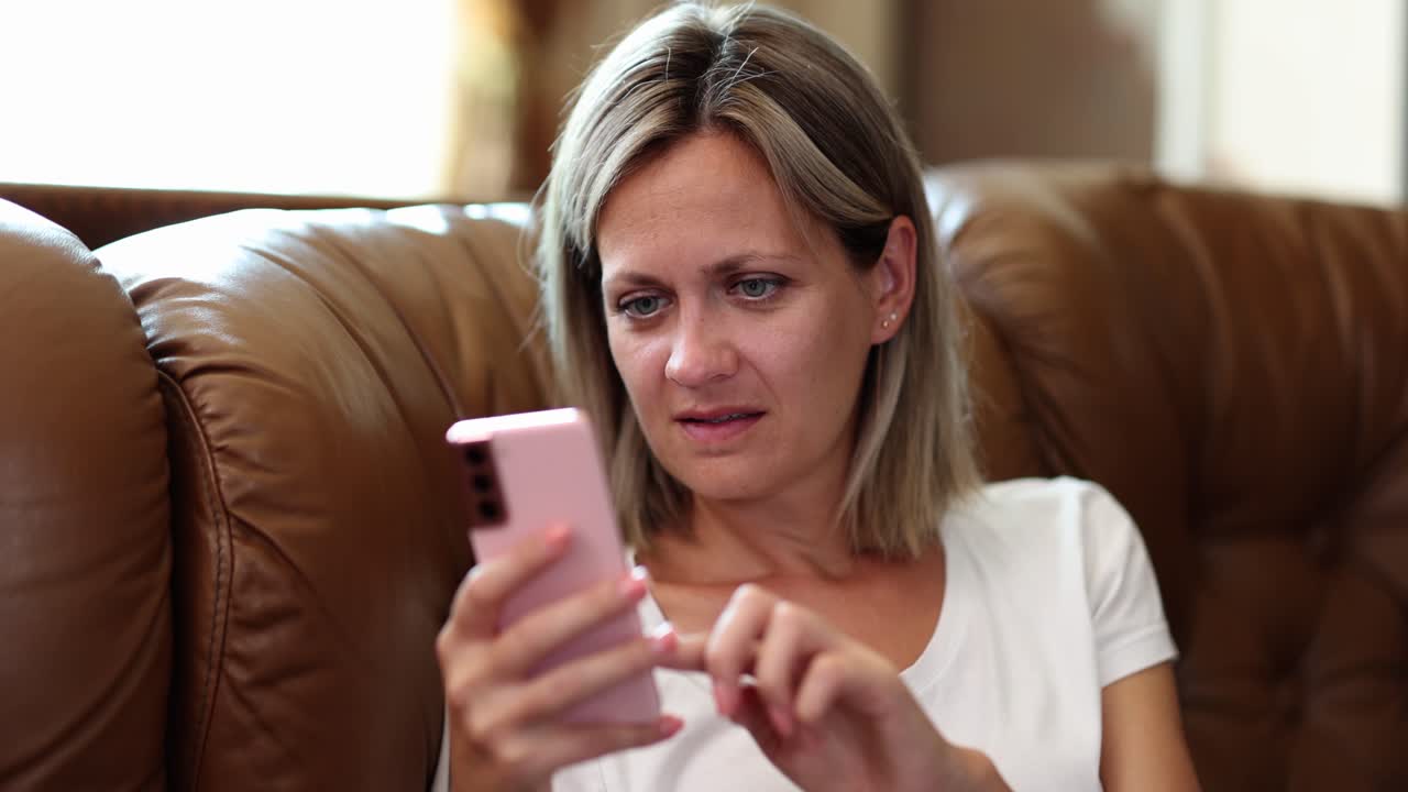 소파에서 스마트폰을 사용하는 여성