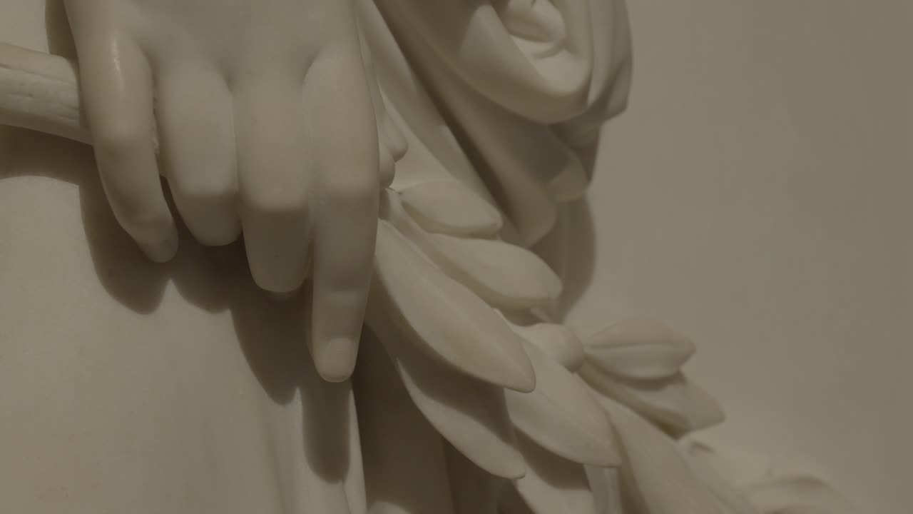 close-up shot of a marble statue holding a branch with flowers
