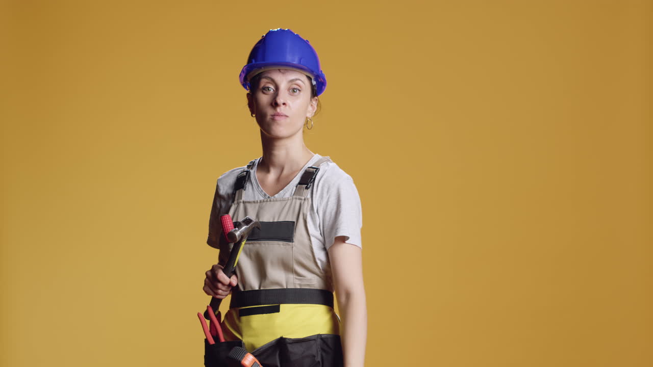 Portrait of engineer holding hammer and pointing at camera