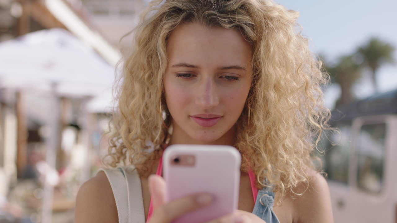 retrato de una mujer rubia hermosa y feliz usando un teléfono inteligente