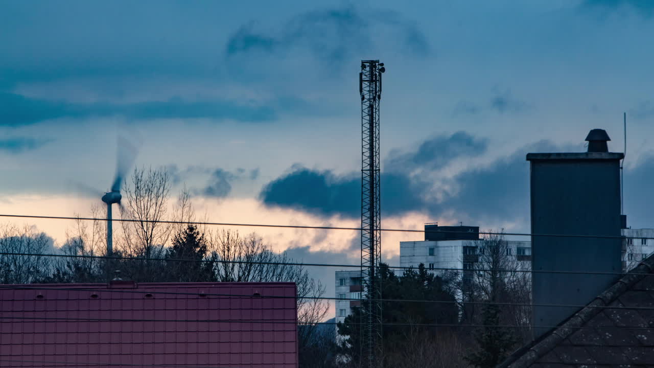 Aikaviivevideo tuulivoimalasta esikaupunkialueella auringonlaskun aikaan