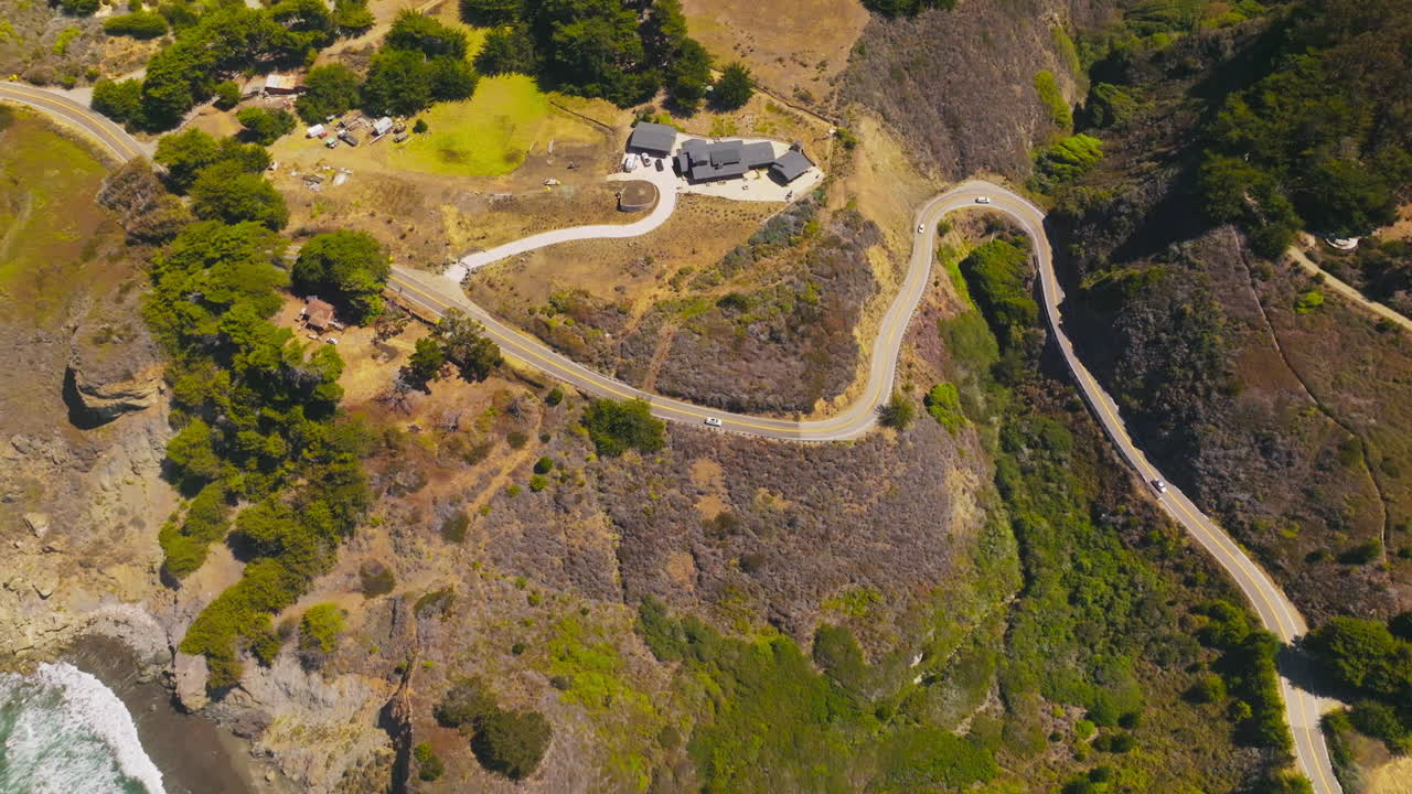 Cozy hotel situated on the rocky shore of Morro Bay. White ways splashing on the craggy rocks of coastline. Top view.