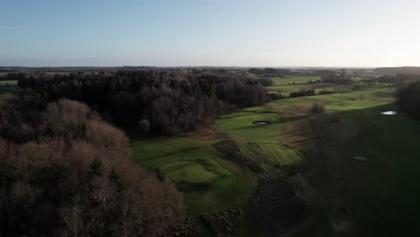 rural landscape aerial view, beautiful golf course in denmark markusminde golf club - dolly in shot and panning shot