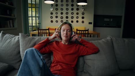 mujer escuchando música en un sofá en casa