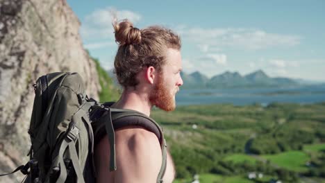 hombre barbudo en la cima de la montaña disfrutando de la vista en noruega