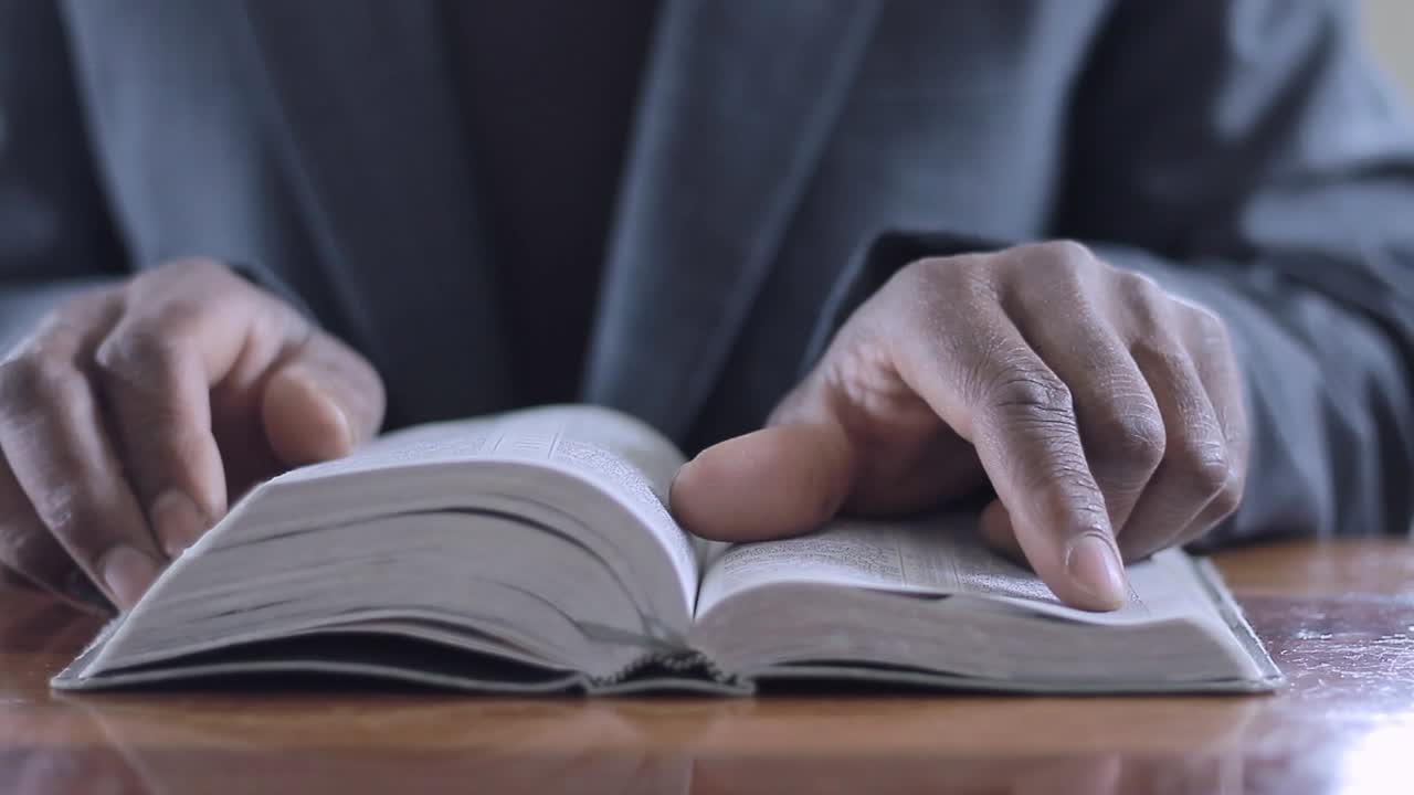 Close-up of hands turning pages of a book