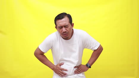 Man-with-abdominal-pain-health-problem-discomfort-diarrhea-isolated-on-yellow-background