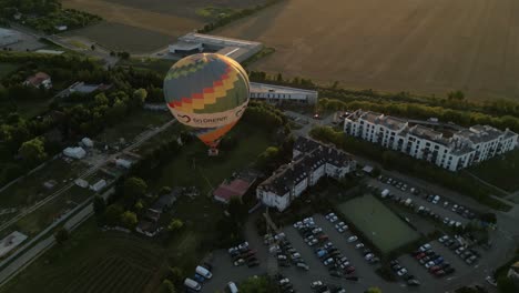 hot air balloon floats over szczecin, poland at golden hour with scenic views of buildings and greenery