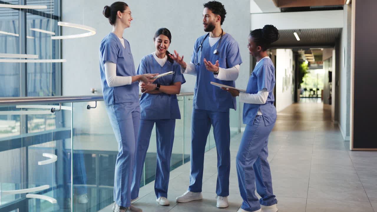Diverse Medical Team in Scrubs Discussing in Modern Hospital Hallway