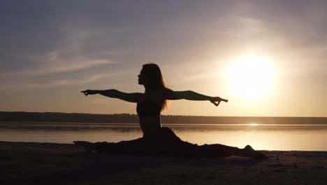 Hermosa-Silueta-De-Mujer-Haciendo-Yoga,-Dividida-En-La-Costa-Del-Mar.-Amanecer-Por-La-Mañana,-Sol-Smog-Sobre-Ti-Detrás-Del-Escenario.