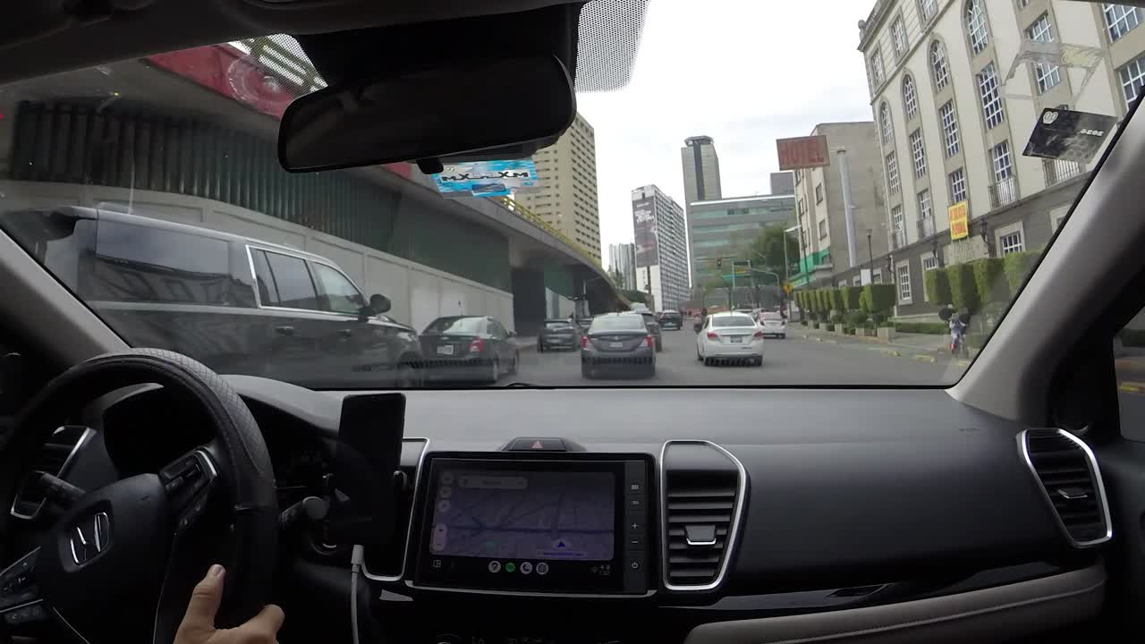 Driving through Mexico City streets with navigation on dashboard in a car interior view