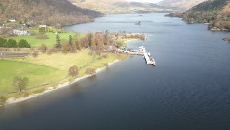 drone panorámica de la izquierda a la derecha del marco frente a un muelle a la orilla del lago olswater en cumbria, inglaterra en el reino unido