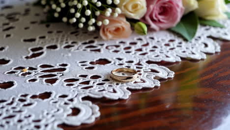 wedding rings and bouquet on a lace tablecloth