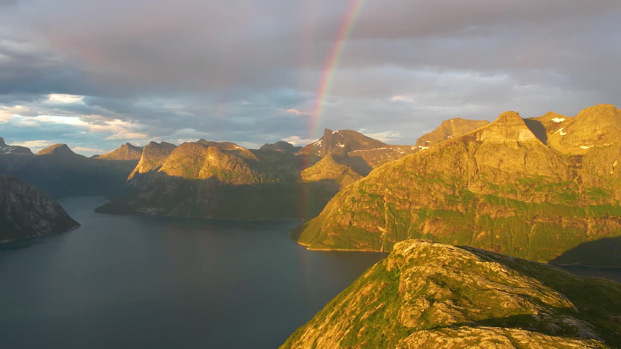 Discover the cinematic beauty of norhern Norway's Finnkonakken's golden hour with amazing rainbow in 4K. Aerial footage showcases dramatic landscapes of northern norway in warm, inviting light.