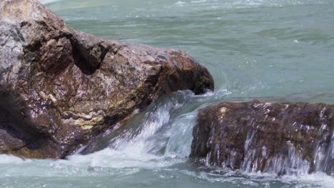 river water flows over a stone and between stones