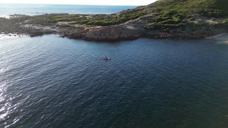 Man-in-kayak-paddling-towards-Australian-coast-of-Gracetown-beach-of-Margaret-River-region,-Australia