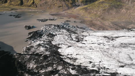 poussée lente vers un petit étang de fonte glaciaire, rempli de sédiments, islande