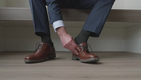 static shot of a man putting his shoes on