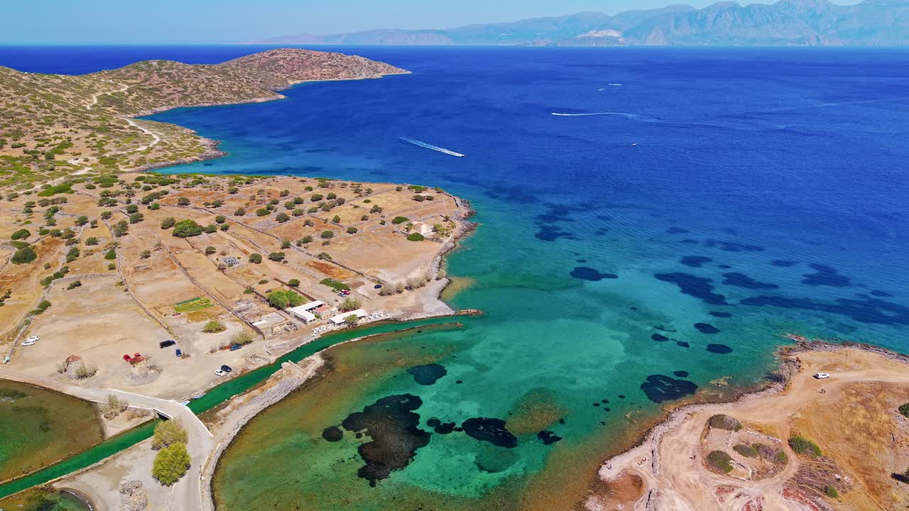 Aerial view of the causeway, town, and blue Aegean Sea at Elounda, Crete