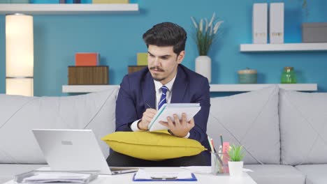 Home-Office-Mitarbeiter-Schaut-Auf-Laptop-Und-Führt-Berechnungen-Durch.