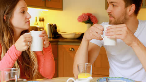 Couple-having-coffee-on-dining-table-in-kitchen-4k