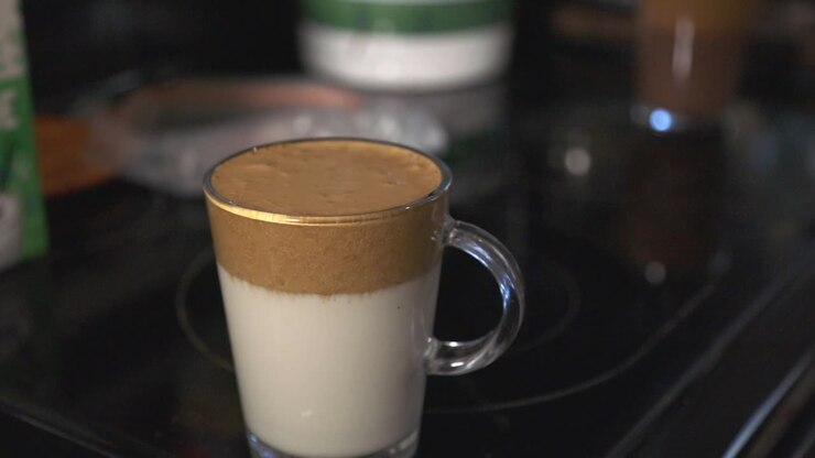 Un bicchiere di delizioso latte macchiato a strati. - primo piano