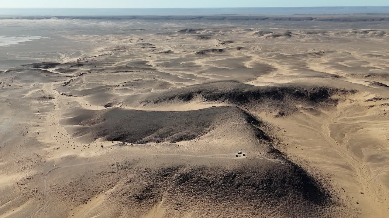 Aerial drone view of rocky desert hills and sandy plains in Mauritania, vast Sahara wilderness with geological formations and endless horizon landscape