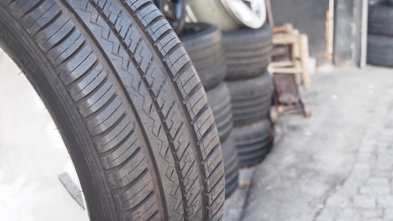 Close-up of a car tire and stacked tires