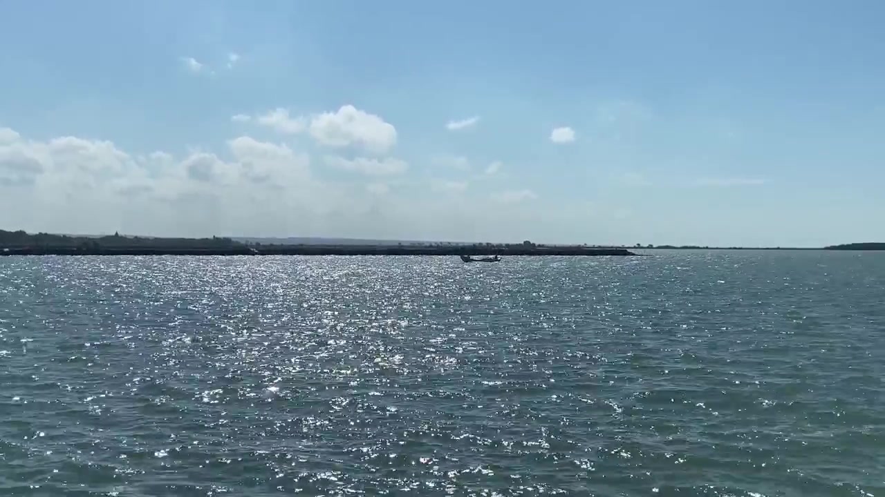 Piccola barca su un mare calmo e blu con la costa in lontananza